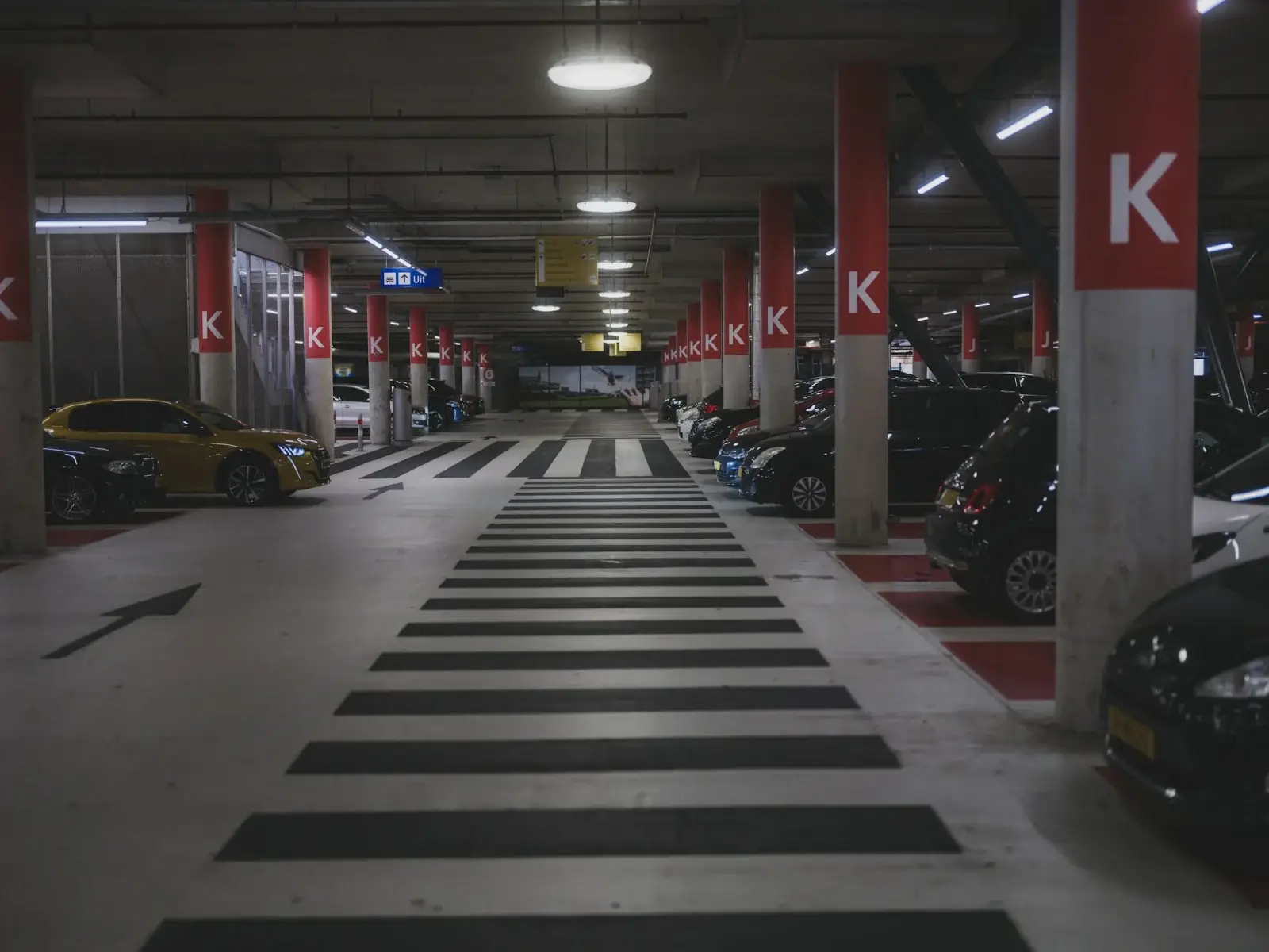 Geparkeerde auto’s in een schemerig verlichte ondergrondse parkeergarage